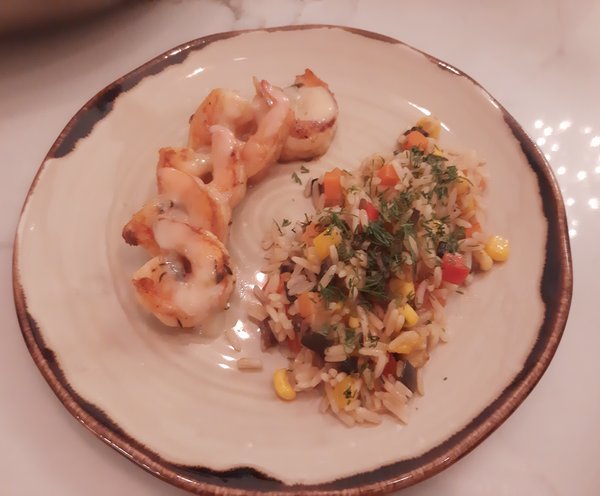 Креветки с диким рисов и овощами, под соусом шампань.